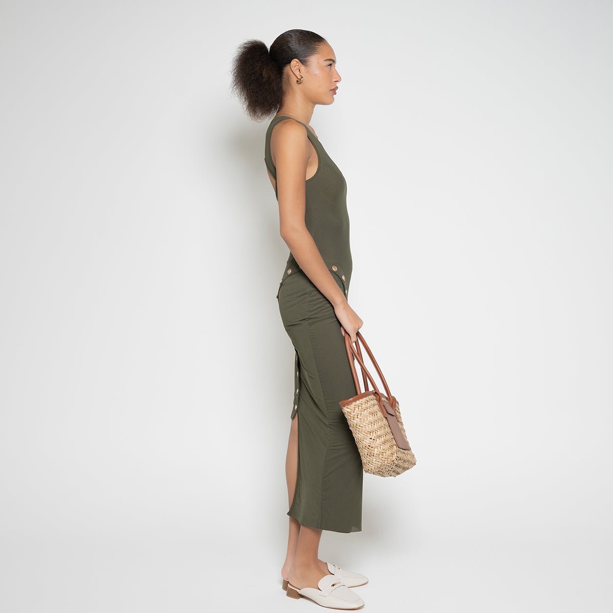 Left side profile of a model wearing the olive green knitted FM Buttoned Maxi Dress by Flashmob Nation.