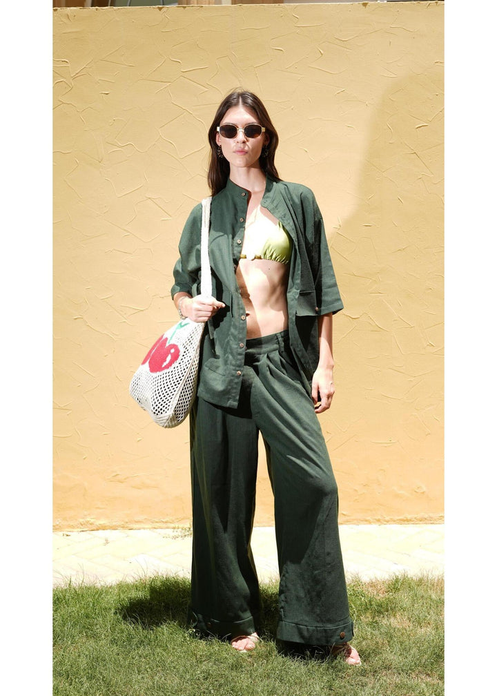 Full length view of model styling the Women's Army Green Linen Carpenter Pants with a matching open shirt by Flashmob Nation.